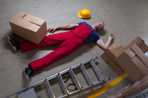 a man lying on the ground after suffering an accident at work